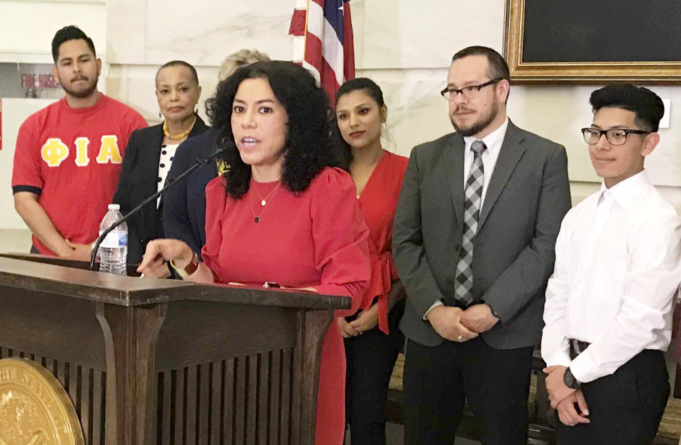 Mireya Reith, foreground, founding executive director of Arkansas United, speaks at a news conference at the state Capitol in Little Rock, Ark., Wednesday, April 10, 2019, about a bill prohibiting "sanctuary cities." Arkansas Gov. Asa Hutchinson said Wednesday he'll sign legislation cutting off funding to "sanctuary cities" that don't cooperate with federal immigration authorities despite the Republican's objections that the measure could open the door to racial profiling. (AP Photo/Andrew DeMillo)