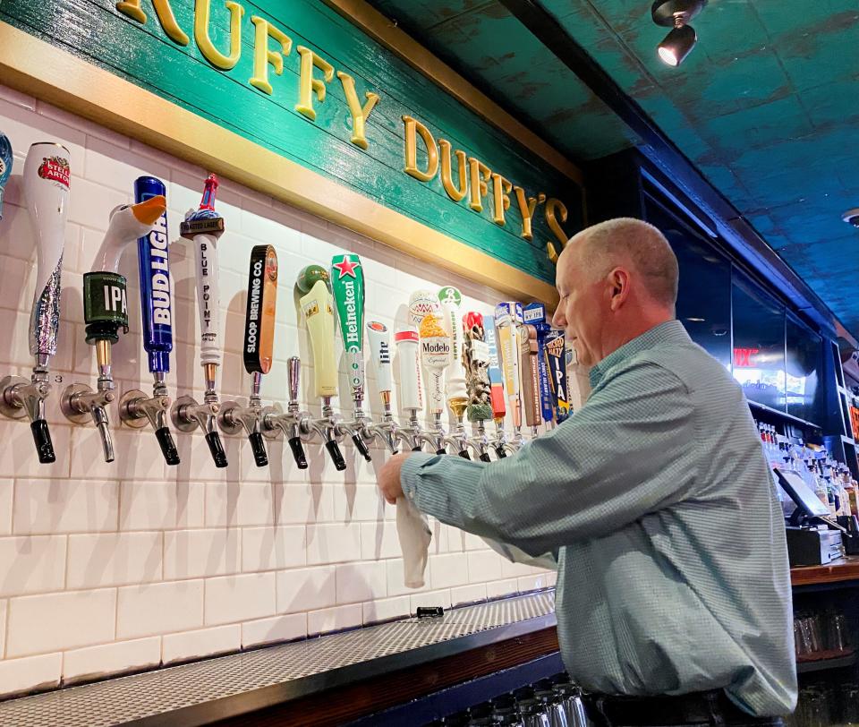 Bar owner Pat Hughes, cleans his beer taps at Scruffy Duffy's, which has been closed for more than a year. in New York, U.S., May 17, 2021. Picture taken May 17, 2021.  REUTERS/Roselle Chen