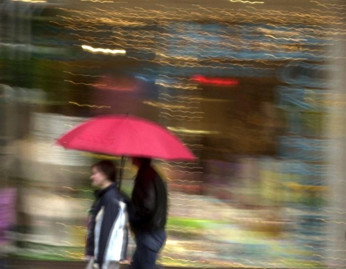 Pedestrians find shelter from the cold rain under an umbrella while strolling down Burlington's Church Street Marketplace in 2004.