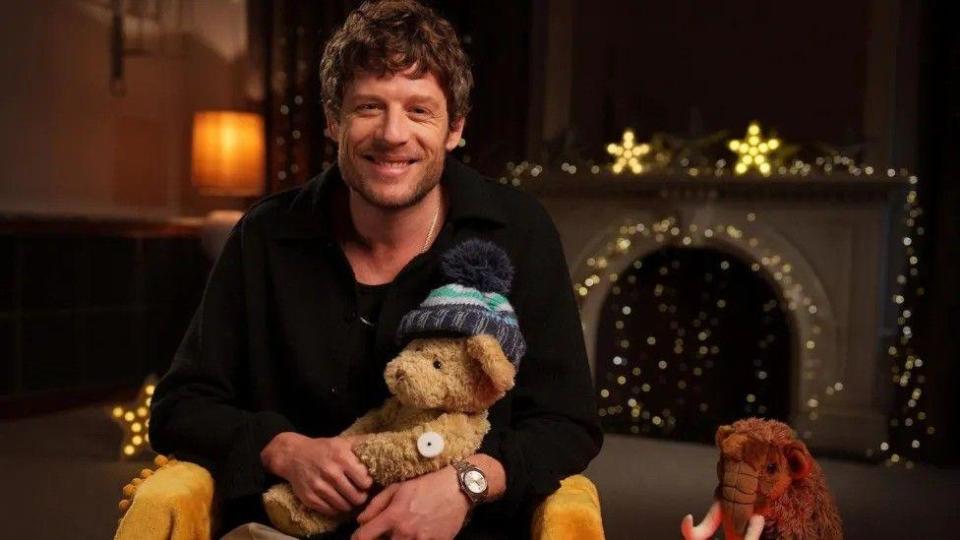 James Norton holding a stuffed bear with diabetes flash monitor, on CBeebies Bedtime Stories