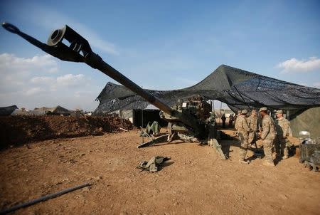 U.S. soldiers from the 2nd Brigade, 82nd Airborne Division gather around an artillery at a military base north of Mosul, Iraq, February 14, 2017. Picture taken February 14, 2017. REUTERS/Khalid al Mousily