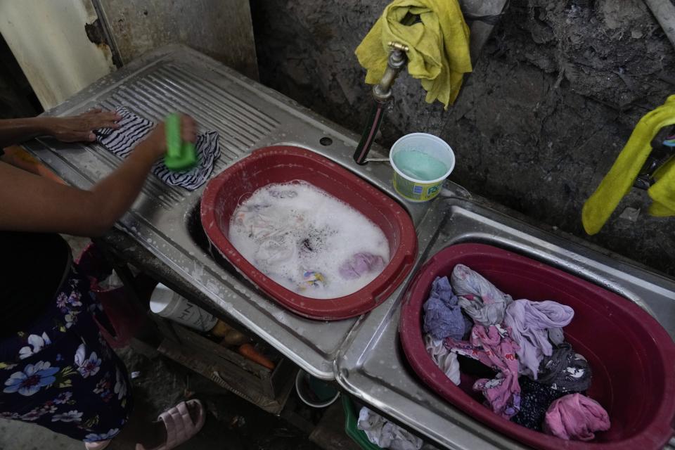 Graciela Mezcua washes her clothes inside of her home in the Pamplona Alta area in Lima, Peru, Monday, March 11, 2024. (AP Photo/Martin Mejia)