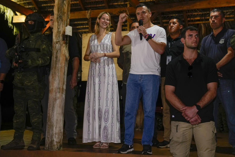 Presidential candidate Daniel Noboa speaks in Olon, Ecuador, after results show him ahead in a snap presidential runoff on Sunday, Oct. 15, 2023. At left is his wife Lavinia Valbonesi. (AP Photo/Martin Mejia)