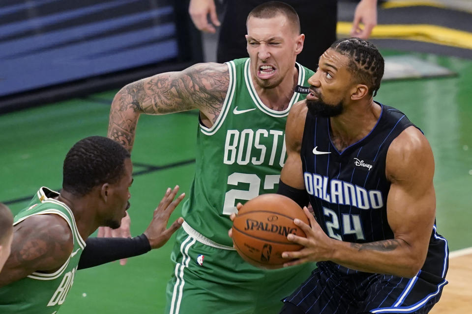 Orlando Magic center Khem Birch (24) looks to shoot against Boston Celtics center Daniel Theis (27) and guard Javonte Green, left, during the first half of an NBA basketball game Friday, Jan. 15, 2021, in Boston. (AP Photo/Elise Amendola)