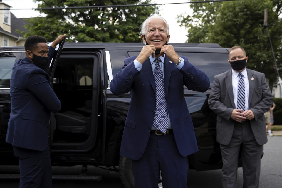 Former Vice President and Democratic presidential candidate Joe Biden pulls down his mask as he makes an unannounced stop at his childhood home on North Washington Avenue in the Green Ridge section of Scranton, Pa. to visit the current homeowner, Anne Kearns, on Thursday, July 9, 2020. (Christopher Dolan / The Times-Tribune via AP)