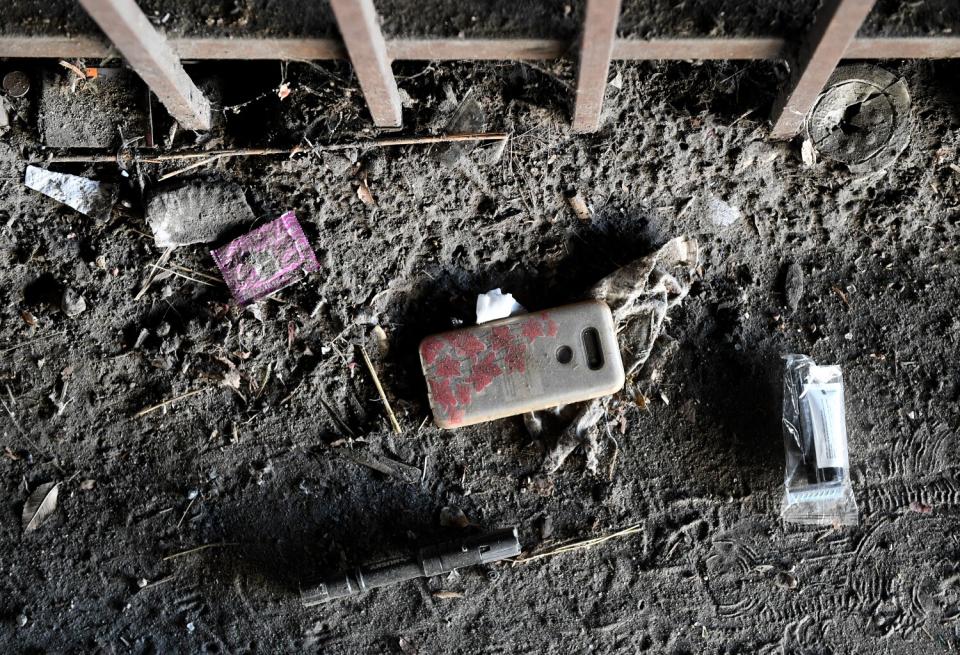 A cellphone case in a path of dirt.