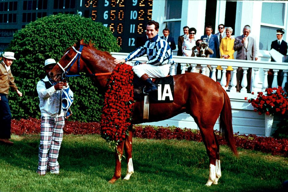 Secretariat and jockey Ron Turcotte pose in the winner's circle after winning the 1973 Kentucky Derby at Churchill Downs.  Holding on at left is groom Eddie Sweet.