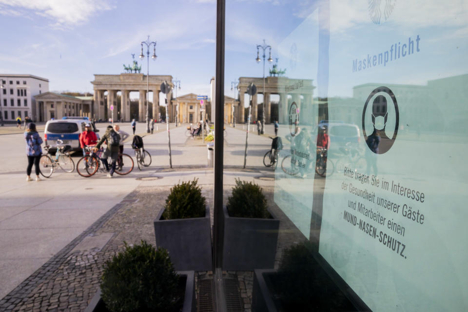 15 November 2020, Berlin: A sign for the mask duty hangs in front of the Brandenburg Gate on the window of a café. Photo: Christoph Soeder/dpa (Photo by Christoph Soeder/picture alliance via Getty Images)