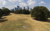 A man sunbathes amidst patches of dried out lawn from a lack of rain in Atlanta, Thursday, Oct. 3, 2019. Scientists say more than 45 million people across 14 Southern states are now in the midst of a drought that's cracking farm soil, drying up ponds and raising the risk of wildfires. (AP Photo/David Goldman)