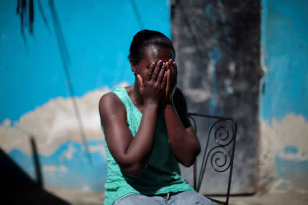 Marieline Jean, who was deported back to Haiti from the United States, covers her face with her hands as she poses for a portrait at the house where she lives, in Port-au-Prince, Haiti, January 30, 2017. REUTERS/Andres Martinez Casares