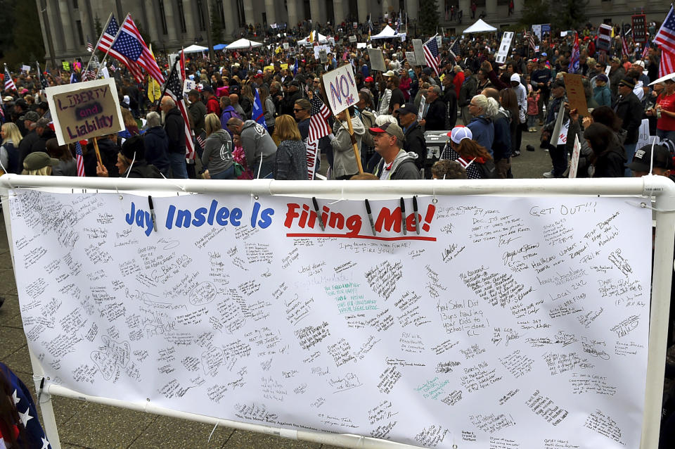 A banner filled with signatures of state employees who may lose their jobs after the Oct. 4 deadline requiring their full vaccination stands on display as people fill the Capitol campus in Olympia, Wash., Sunday, Oct. 3, 2021, to rally against the COVID-19 vaccination mandate by Gov. Jay Inlsee. (Steve Bloom/The Olympian via AP)