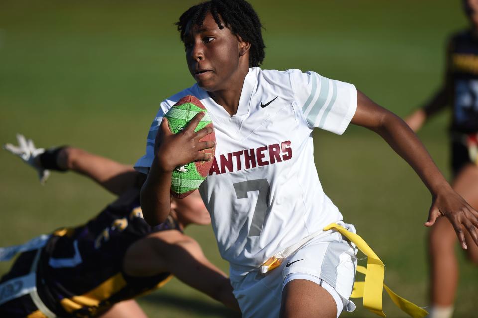 Fort Pierce Westwood Academy's Jihla Greer (7) runs through Fort Pierce Central defenders during their flag football game on Thursday, March 23, 2023, at Fort Pierce Central High School. Westwood Academy won 7-6.