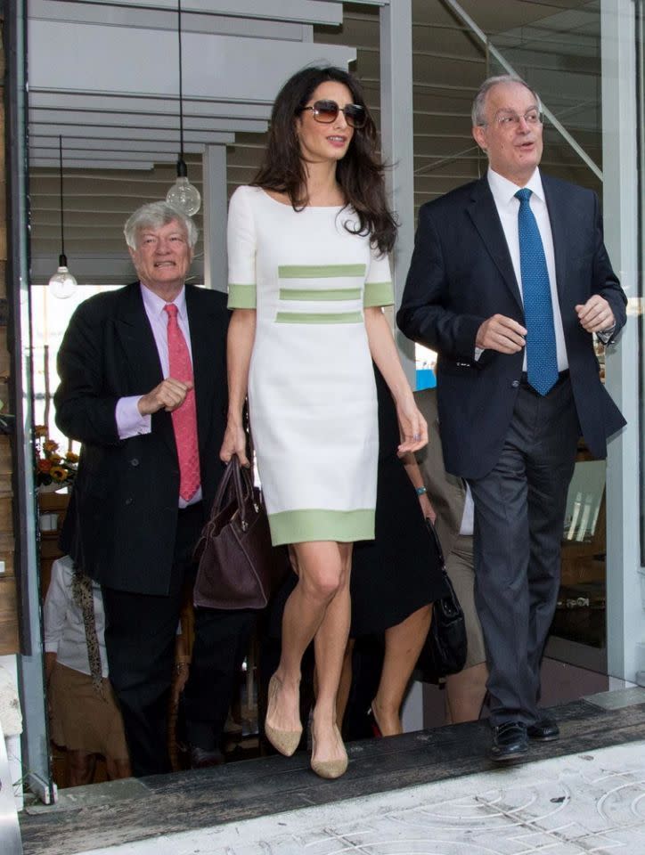 Amal Clooney en Grèce, portant une robe blanche Camillo Bona avec des ornements verts.