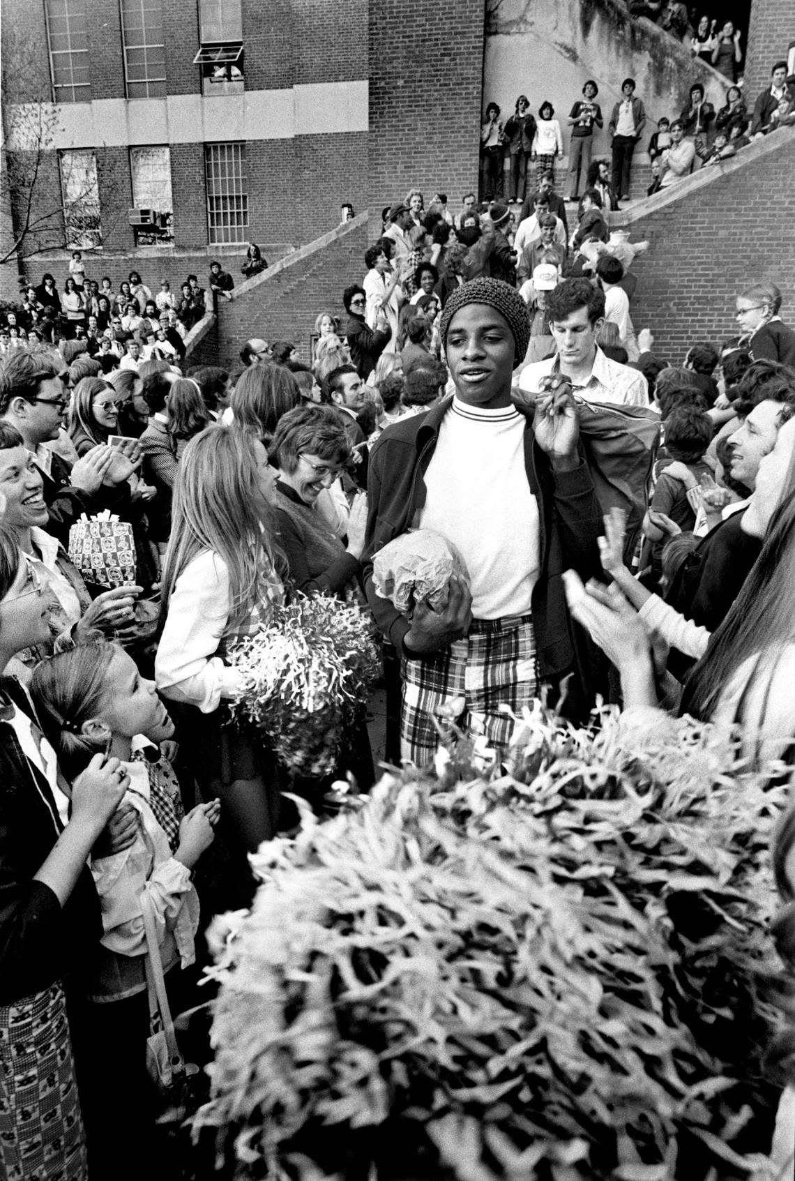 NC State’s David Thompson makes his way through a crowd of fans and cheerleaders as he and other Wolfpack players board a bus to take them the the 1974 National Championship.