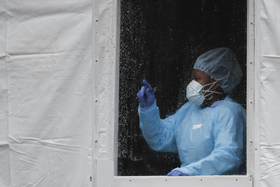 A medical worker gestures at a COVID-19 testing station at The Brooklyn Hospital Center, Monday, March 23, 2020, in New York. (AP Photo/John Minchillo)