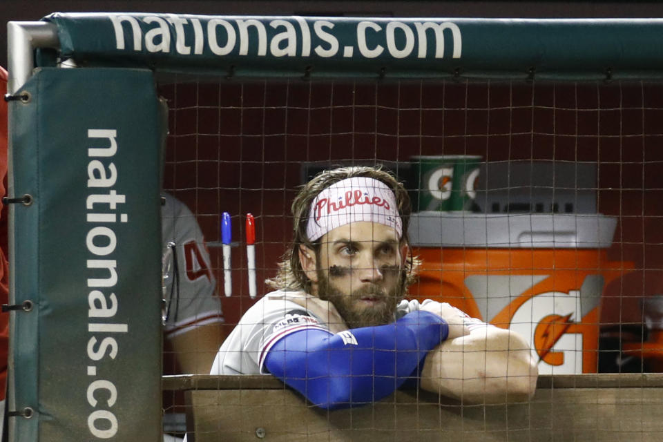 Philadelphia Phillies right fielder Bryce Harper stands in the dugout during the ninth inning of the team's baseball game against the Washington Nationals, Thursday, Sept. 26, 2019, in Washington. Washington won 6-3. (AP Photo/Patrick Semansky)