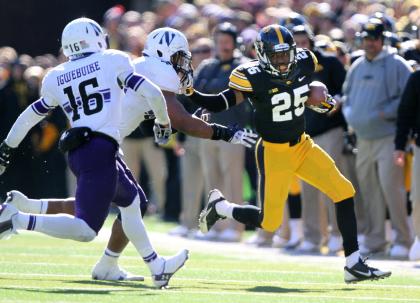 Iowa running back Akrum Wadley (25) stiff arms Northwestern linebacker Chi Chi Ariguzo (44). Saturday, Nov. 1, 2014, in Iowa City, Iowa . (AP Photo/Justin Hayworth)