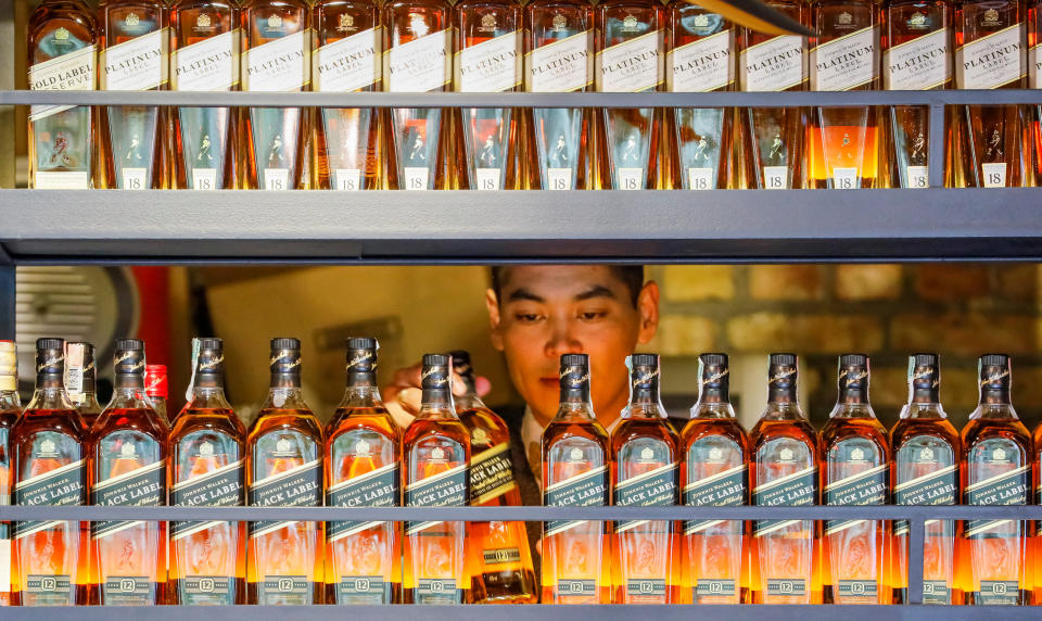 A bartender takes a bottle of Johnnie Walker whisky at Barmaglot bar in Almaty, Kazakhstan June 22, 2017. Photo: REUTERS/Shamil Zhumatov/File Photo