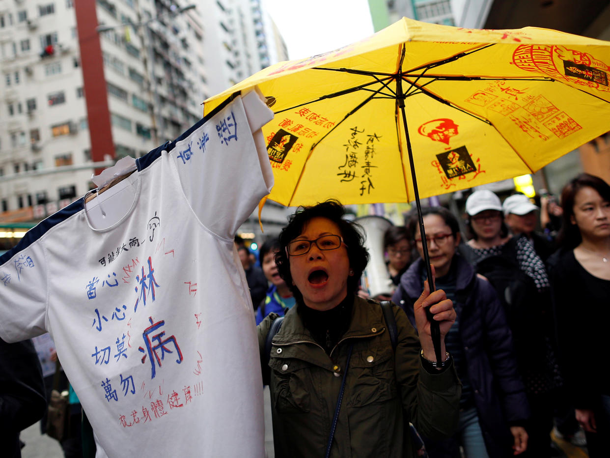 A protester holds up a yellow umbrella, the symbol of the Occupy Central movement, as she marches to demand universal suffrage in Chief Executive election in Hong Kong: REUTERS/Tyrone Siu