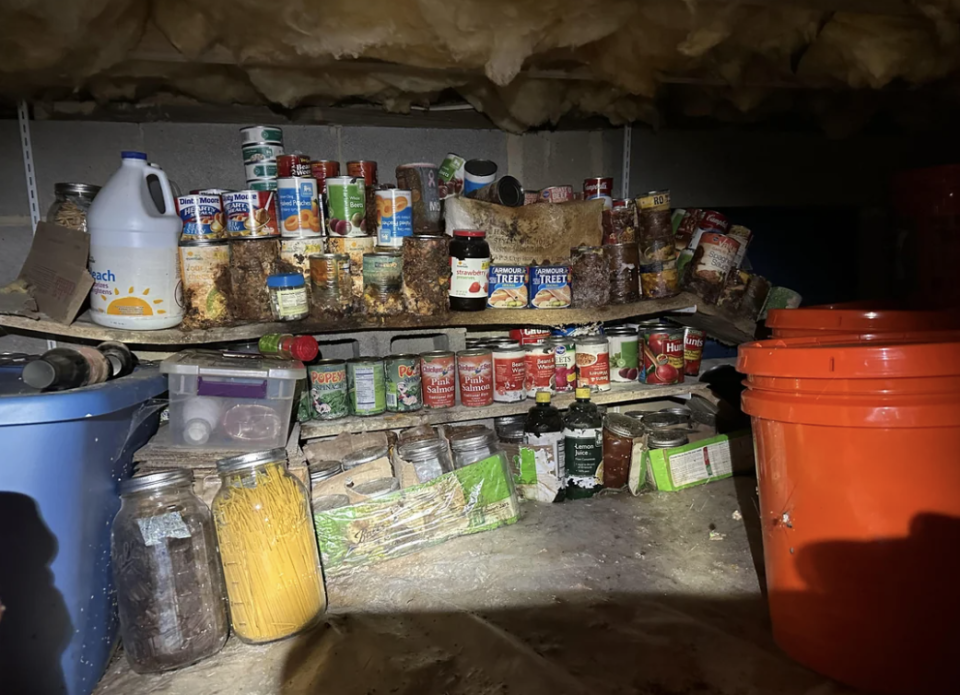 A cluttered pantry shelf with various food items, containers, and a jug