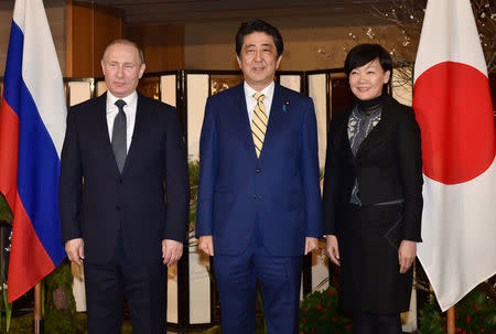 REFILE - CORRECTING TYPO Russian President Vladimir Putin (L), Japanese Prime Minister Shinzo Abe (C), and Abe's wife Akie pose for the media at a hotel in Nagato, Yamaguchi prefecture, Japan December 15, 2016. REUTERS/Kazuhiro Nogi/Pool