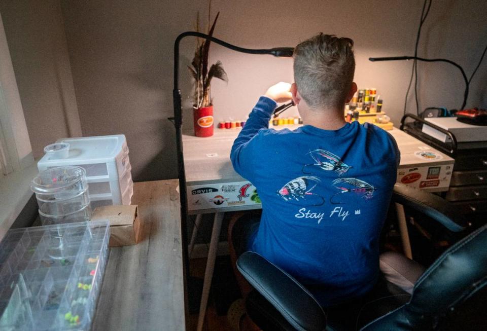 Landis Sampsel, 12, makes makes a collection of fly fishing flies at his desk on Thursday, July 13, 2023.