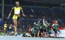 2016 Rio Olympics - Athletics - Final - Women's 100m Final - Olympic Stadium - Rio de Janeiro, Brazil - 13/08/2016. Photographers work as Elaine Thompson (JAM) of Jamaica wins gold in the women's 100m final. REUTERS/Lucy Nicholson