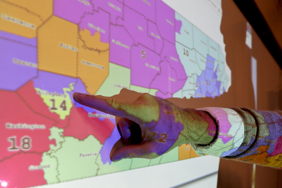 William Marx points out one of the districts that crossed four counties as an image of the old congressional districts of Pennsylvania are projected on a wall in the classroom where he teaches civics in Pittsburgh on Friday, Nov. 16, 2018. Marx was a plaintiff in the Pennsylvania lawsuit that successfully challenged the Republican-drawn congressional maps. Marx said he believes the new district boundaries resulted in "a more fair congressional representation of the will of the people in Pennsylvania." (AP Photo/Keith Srakocic)