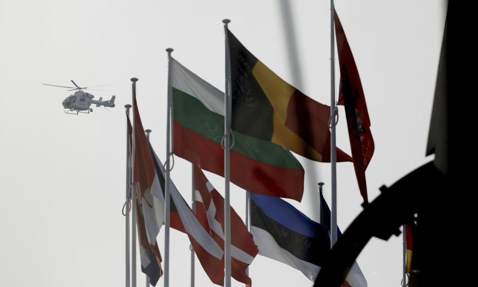 A police helicopter flies over NATO member country flags during a meeting of NATO defense ministers at NATO headquarters in Brussels, Wednesday, March 16, 2022. NATO Secretary-General Jens Stoltenberg made it clear Tuesday that the 30-nation military alliance is set to radically change its security stance in Europe in response to Russia's war on Ukraine. (AP Photo/Olivier Matthys)