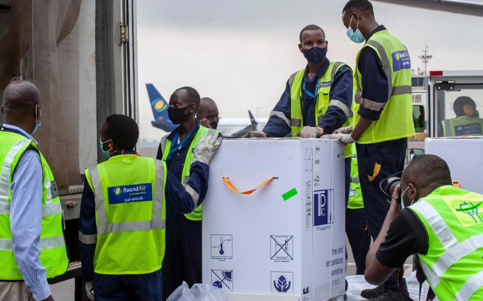 A shipment of vaccines is received by airport workers at the airport in Kigali, Rwanda - Muhizi Olivier/AP Photo