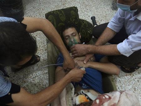 A man, affected by what activists say is nerve gas, breathes through an oxygen mask in the Damascus suburbs of Jesreen August 21, 2013. REUTERS/Ammar Dar