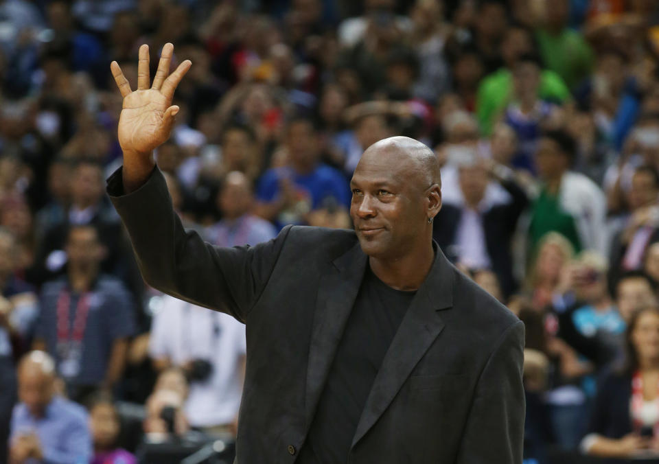 NBA basketball legend Michael Jordan waves during the match of Charlotte Hornets against the Los Angeles Clippers at the 2015 NBA Global Games in Shenzhen, south China's Guangdong province, Sunday, Oct. 11, 2015. (AP Photo/Kin Cheung)