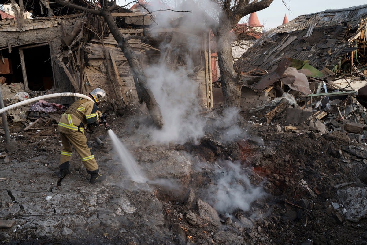 Firefighters extinguish a fire next to houses destroyed during a Russian attack on Kyiv (Roman Hrytsyna/AP) (AP)