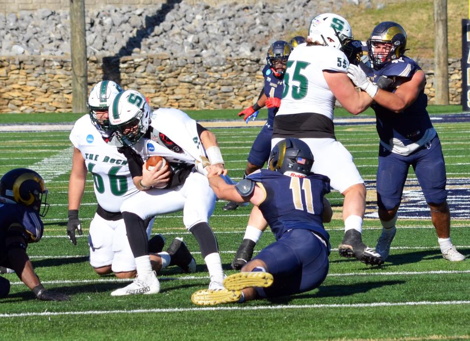 Shepherd defensive end Kyle Smith (11) brings down Slippery Rock quarterback Noah Grover for a sack during the Rams' 37-27 win in the second round of the NCAA Division II playoffs.