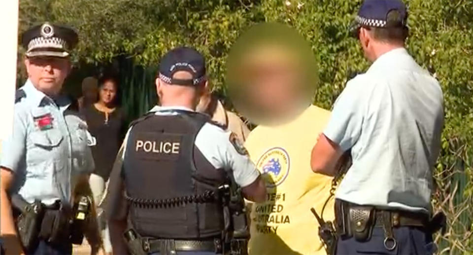 Police speak to the alleged offender outside the polling place at Bankstown Public School.