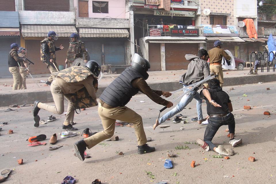 TOPSHOT - Police clash with protesters during demonstrations against India's new citizenship law in Lucknow on December 19, 2019. - Indians defied bans on assembly on December 19 in cities nationwide as anger swells against a citizenship law seen as discriminatory against Muslims, following days of protests, clashes and riots that have left six dead. (Photo by STR / AFP) (Photo by STR/AFP via Getty Images)