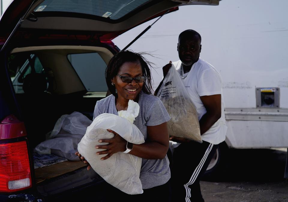 Yolande Rolle carries sandbags to place at her shop&#39;s doorstep as she prepares for the arrival of Hurricane Dorian in Freeport on Grand Bahama, Bahamas, Sunday, Sept. 1, 2019. Hurricane Dorian intensified yet again Sunday as it closed in on the northern Bahamas, threatening to batter islands with Category 5-strength winds, pounding waves and torrential rain. (AP Photo/Ramon Espinosa)