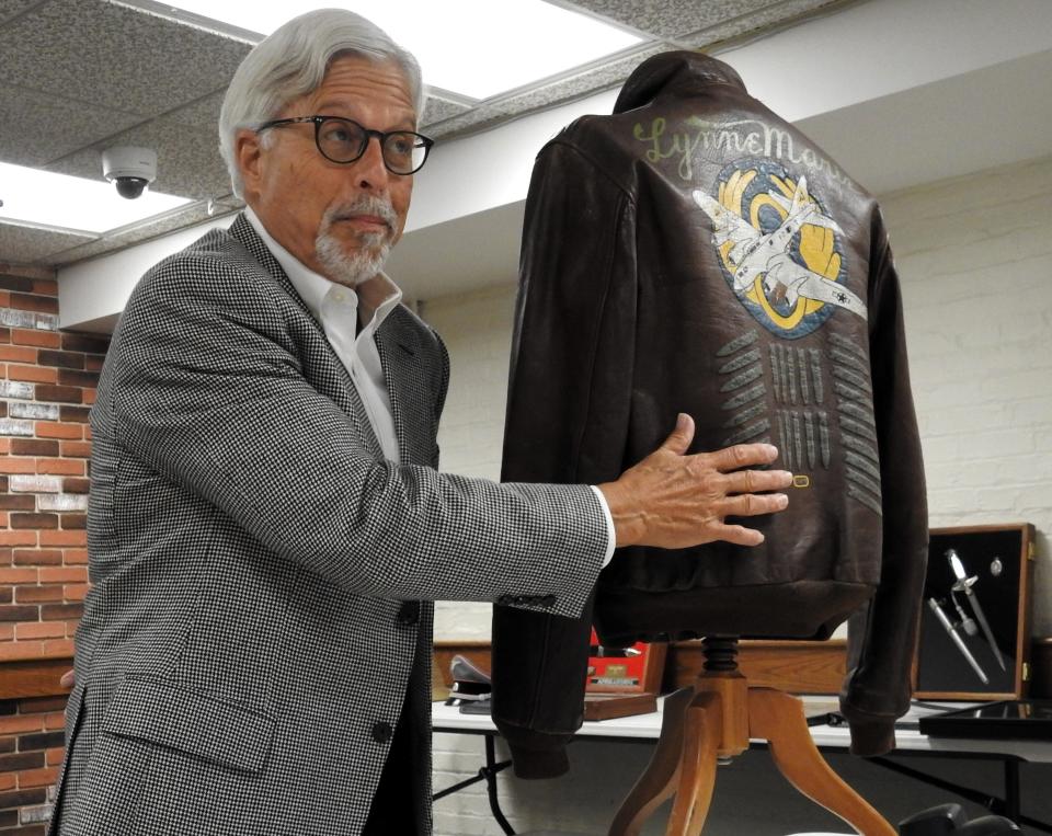 Bill Given displays a bomber jacket from World War II featuring a hand painted back during a recent presentation at the Coshocton County District Library. Given has more than 1,000 military items ranging from the American Revolution to the Vietnam War.