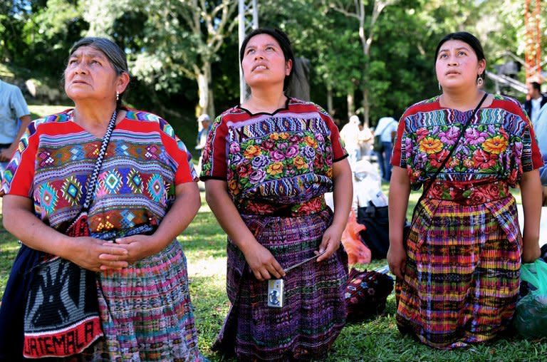 Guatemalan Maya natives kneel in front of a temple at the Tikal archaeological site on December 20, 2012. The exquisite site of Mayan ruins began hosting winter solstice ceremonies on Thursday as the region's indigenous people marked the end of an era