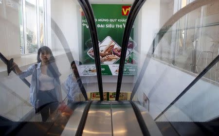 Customers take an escalator at a V+ supermarket in Hanoi, Vietnam June 29, 2015. REUTERS/Kham