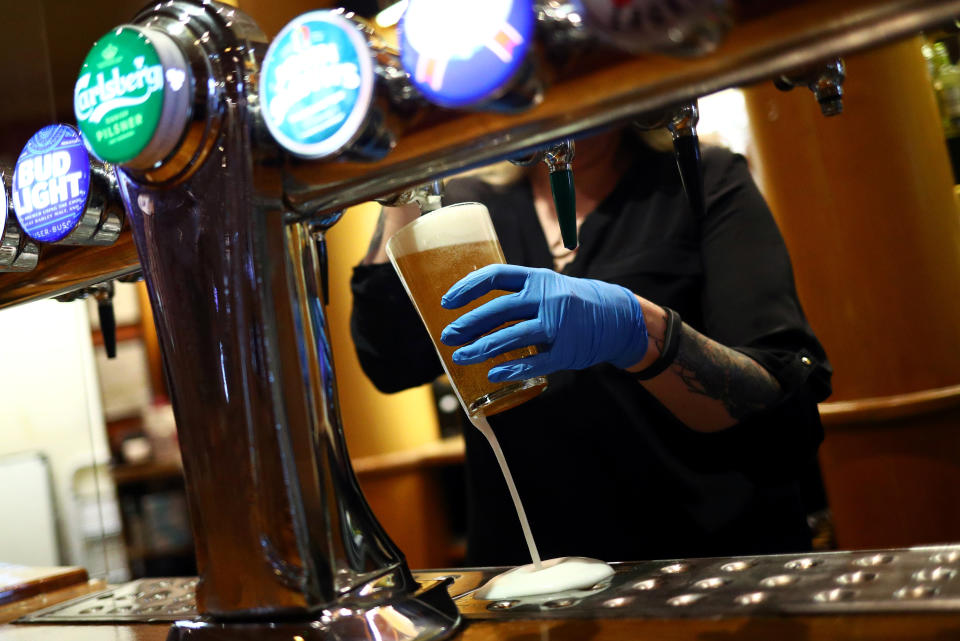 Wetherspoon  A worker serves a beer at The Holland Tringham Wetherspoons pub after it reopened following the outbreak of the coronavirus disease (COVID-19), in London, Britain July 4, 2020. REUTERS/Hannah McKay