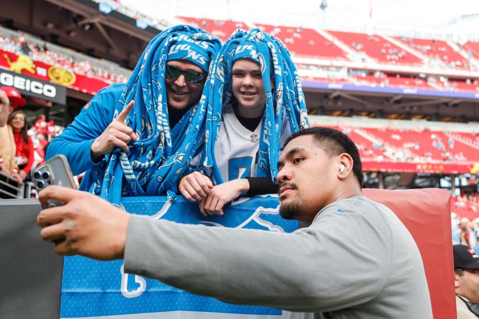 Detroit Lions offensive tackle Penei Sewell takes a selfie with Zach Kelsey and his son Sawyer, 13, both of Twin Falls, Idaho during warm up before the NFC championship game against San Francisco 49ers at Levi's Stadium in Santa Clara, Calif. on Sunday, Jan. 28, 2024.
