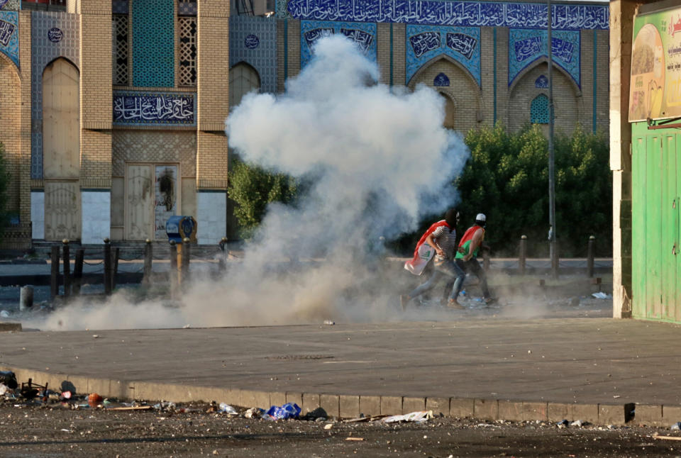 Riot police fire tear gas during clashes between Iraqi security forces and anti-government demonstrators, at Khilani Square in Baghdad, Iraq, Friday, Nov. 15, 2019. (AP Photo/Khalid Mohammed)