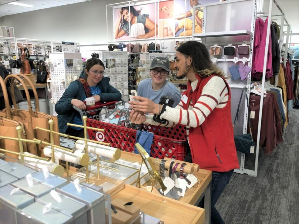 Target Front Manager Eddie Ibarra helps customers Christina Ottey (left) of Allentown and her sister, Kalyn Sourwine of Falls with some jewelry selections at the store in Middletown early Black Friday morning.