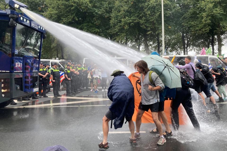 Dutch police uses water cannon to clear climate activists from the highway in The Hague, Netherlands (HANNAH PRINS via REUTERS)