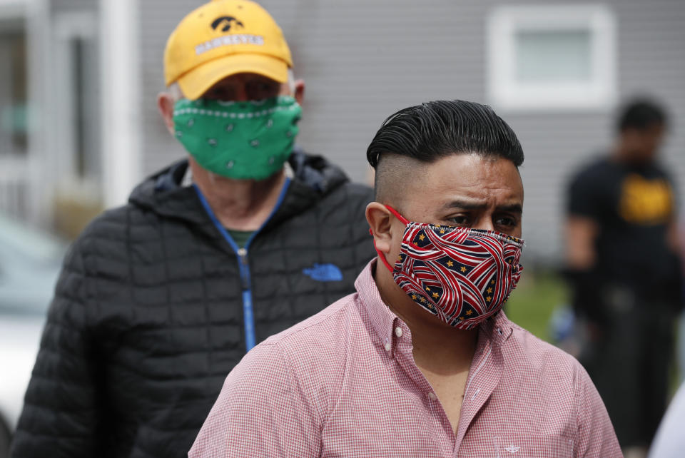 Local residents line up to buy chicken dinners during a fundraiser for the Omar Martinez family Saturday, April 25, 2020, in West Liberty, Iowa. Martinez's family had been living the American dream after immigrating from Mexico in the 1990s and settling in this small town in eastern Iowa, but their lives fell apart after coronavirus infections spread from his mother to his sister and his father. (AP Photo/Charlie Neibergall)