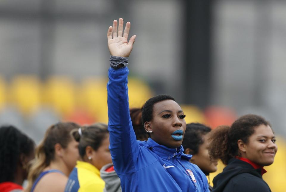 Athlete with raised arm waving at crowd.