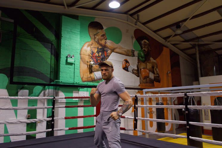 Conor McGregor poses in front of a mural showing him boxing Floyd Mayweather. (Courtesy photo)