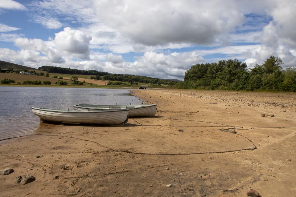 Row boats sit on sand on the edge of low water (Katielee Arrowsmith SWNS)