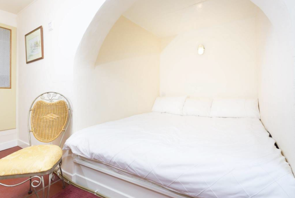 <p>The master bedroom is a converted cellar and keg store. However, its beer-barrel delivery door and sloping floors remain in place. (Airbnb) </p>